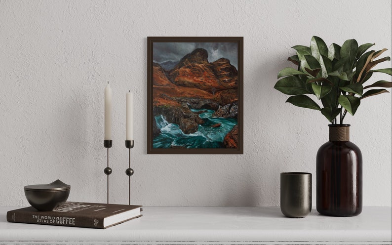 May include: Framed landscape painting of a river flowing through a rocky canyon with a cloudy sky in the background.