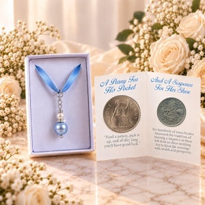 Op de afbeelding: Een lichtblauwe lintbedel met een parel en een blauwe kraal in een witte doos, naast een kaart met een Britse penny en een sixpence-munt, met de tekst A Penny For His Pocket en And A Sixpence For Her Shoe, plus bijbehorende tekst.