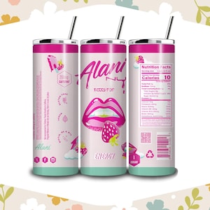 May include: Three Alani Nu Berry Pop energy drink tumblers with straws. The tumblers are white with pink accents and feature a graphic of lips and a strawberry. The tumblers also have nutritional information and the text "200mg Caffeine".