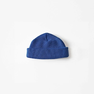Peut inclure: Un bonnet en tricot bleu. Le bonnet est plié vers le bas au niveau du bord.
