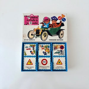Peut inclure: Un jeu de domino vintage pour enfants avec des illustrations de panneaux de signalisation et de voitures. La boîte est bleue et blanche avec le titre "Domino du Code de la Route" et le nom "Fernand Nathan".