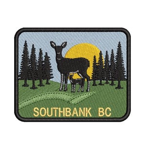 Könnte beinhalten: Gestickter Aufnäher mit einer schwarzen Hirsch- und Kitzsilhouette vor einer gelben Sonne und hellblauem Himmel. Dunkelgrüne Kiefern umrahmen die Szene. Der Text "SOUTHBANK BC" ist goldfarben gestickt.