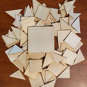 May include: A pile of wooden shapes, including squares and triangles, in various sizes. The shapes are all made of light-colored wood and are arranged in a random pattern.