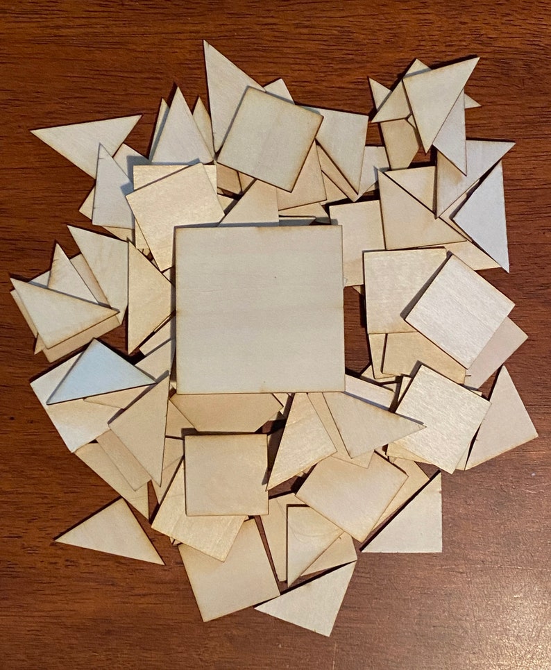 May include: A pile of wooden shapes, including squares and triangles, in various sizes. The shapes are all made of light-colored wood and are arranged in a random pattern.