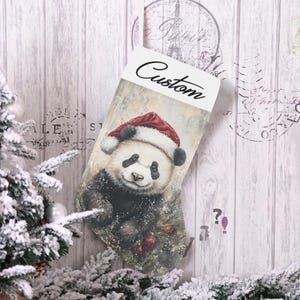 May include: A Christmas stocking featuring a panda wearing a Santa hat. The panda is depicted with black and white fur, a red hat, and is surrounded by pine needles and ornaments. The word "Custom" is written on the top.