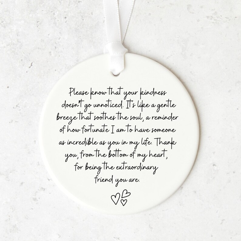 May include: White ceramic ornament with a handwritten message that reads: "Please know that your kindness doesn't go unnoticed. It's like a gentle breeze that soothes the soul, a reminder of how fortunate I am to have someone as incredible as you in my life. Thank you, from the bottom of my heart, for being the extraordinary friend you are."