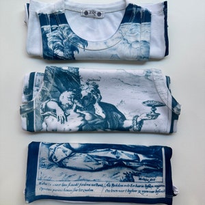 May include: Three white tank tops with blue and white printed designs. The designs are of a landscape, a couple, and a scene with text. The text reads: "Mistus in creet lous frimodi fiodera ne&scaron;tunt, Als Rockdom onde Eer haerin lighten vengarm Opratem parent homms fine lite quidem. Ons leven nacrt bagheer ze soyen van befivar"