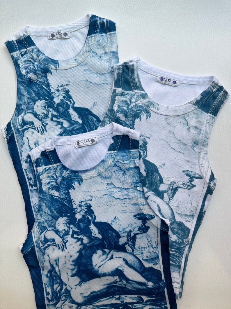 May include: Three white tank tops with a blue and white print of a reclining figure with a crown and a chalice. The tank tops have a ribbed texture and a small tag with the word "ZOZ" on the front.