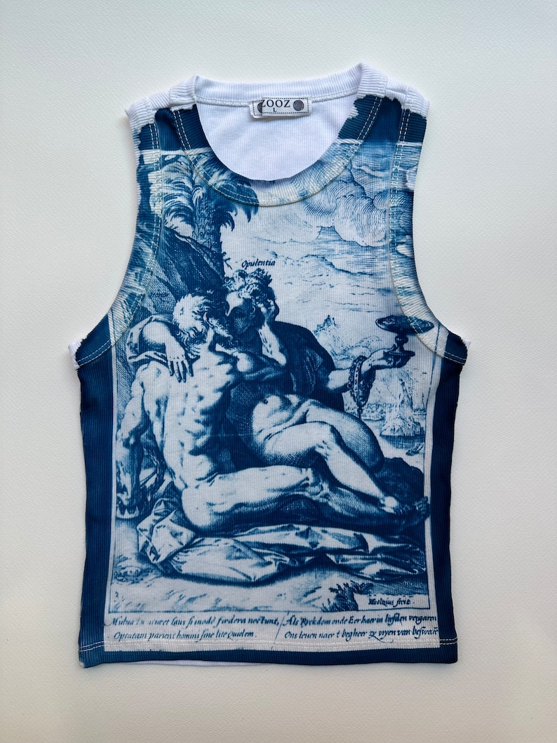 May include: A white tank top with a blue and white print of a Renaissance-era scene. The print features two figures, a man and a woman, embracing. The text at the bottom of the print reads "Mutua in curet laus fmodi fodera no&eacute;tunt, Als Provkdom onde Eer har in liefden waarm Opratam parent hams fine lite quidem. Ons lewen nacrt bogheer zy wyen van befivar."
