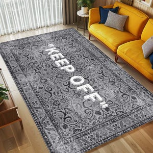 May include: A gray and white patterned rug with the text "KEEP OFF!" in white lettering.