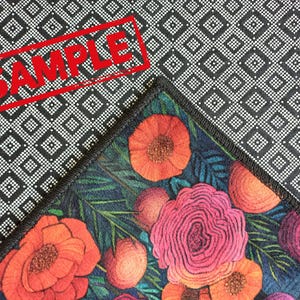 Puede incluir: Una tela con estampado en blanco y negro con un dise&ntilde;o floral. El dise&ntilde;o floral presenta flores rojas, rosas y naranjas sobre un fondo azul oscuro.