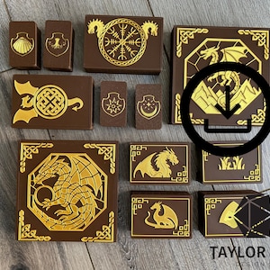 Puede incluir: Colección de cajas y contenedores marrones con diseños dorados en relieve. Los diseños incluyen dragones, escudos y nudos celtas. Las cajas varían en tamaño y forma.