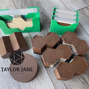 May include: Two bright green plastic card holders containing stacks of playing cards, accompanied by several brown, hexagonal, wood-grain textured card organizers and a circular brown coaster featuring a tree ring pattern and the text TAYLOR JANE DESIGN CO.
