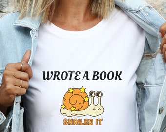 Könnte beinhalten: Weißes T-Shirt mit einer Comic-Schnecke und dem Text "Wrote a book, Snailed it".