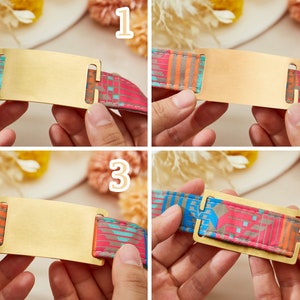 May include: A close-up of a gold-colored metal tag with a rectangular shape. The tag is attached to a colorful patterned fabric strap. The tag is blank and ready to be engraved.