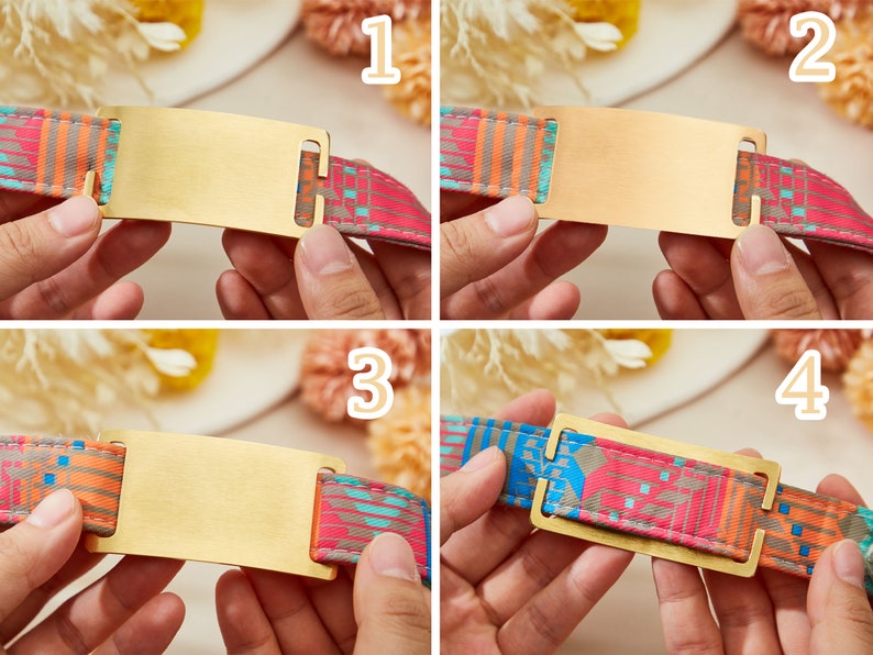 May include: A close-up of a gold-colored metal tag with a rectangular shape. The tag is attached to a colorful patterned fabric strap. The tag is blank and ready to be engraved.