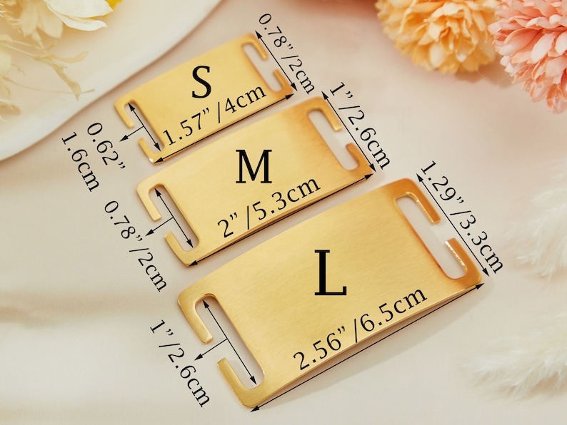 May include: Three gold-colored metal dog collar tags with different sizes labeled "S", "M", and "L". The tags have measurements in inches and centimeters.
