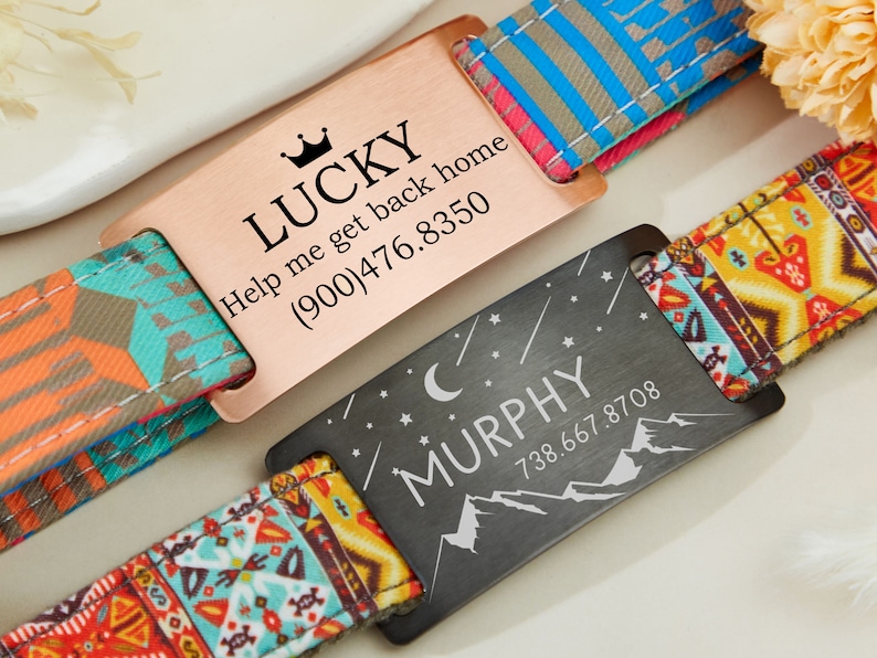 May include: Two personalized dog tags with colorful patterned straps. The first tag is rose gold with the text "LUCKY Help me get back home (900)476.8350". The second tag is black with the text "MURPHY 738.667.8708" and a crescent moon and mountain design.