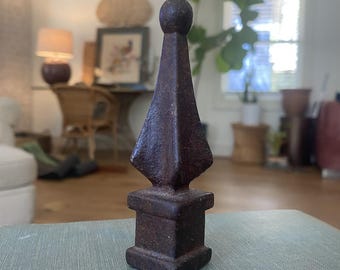 Remate antiguo de hierro fundido, pequeño elemento arquitectónico recuperado, decoración rústica de metal.