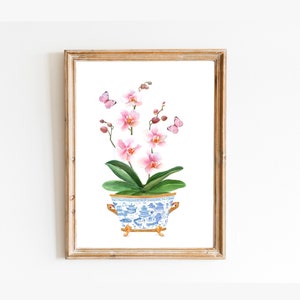 May include: A watercolor painting of a pink orchid plant in a blue and white porcelain pot with gold accents. The plant is in a white background with butterflies.