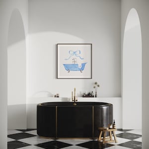 Peut inclure: Une baignoire autoportante noire avec des accents dor&eacute;s est pos&eacute;e sur un sol en damier noir et blanc. Un tableau aquarelle encadr&eacute; d'une baignoire bleue avec un n&oelig;ud bleu sur le dessus est accroch&eacute; au mur au-dessus de la baignoire.