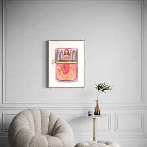 Puede incluir: Una ilustraci&oacute;n de acuarela de una sirena en una lata rosa de sardinas. La sirena lleva un sujetador de concha y tiene una cola roja. La lata est&aacute; etiquetada con "SARDINES" en letras doradas.