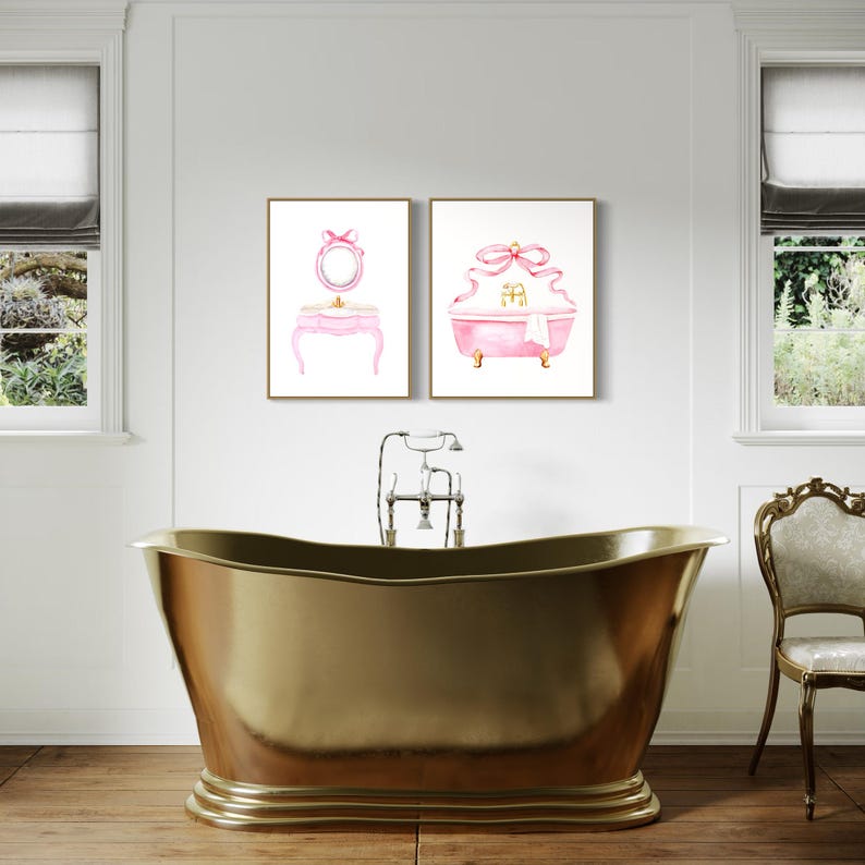 May include: Two framed watercolor illustrations of a pink vanity set and a pink bathtub with a large pink bow on each. The illustrations are hung on a white wall in a bathroom setting.