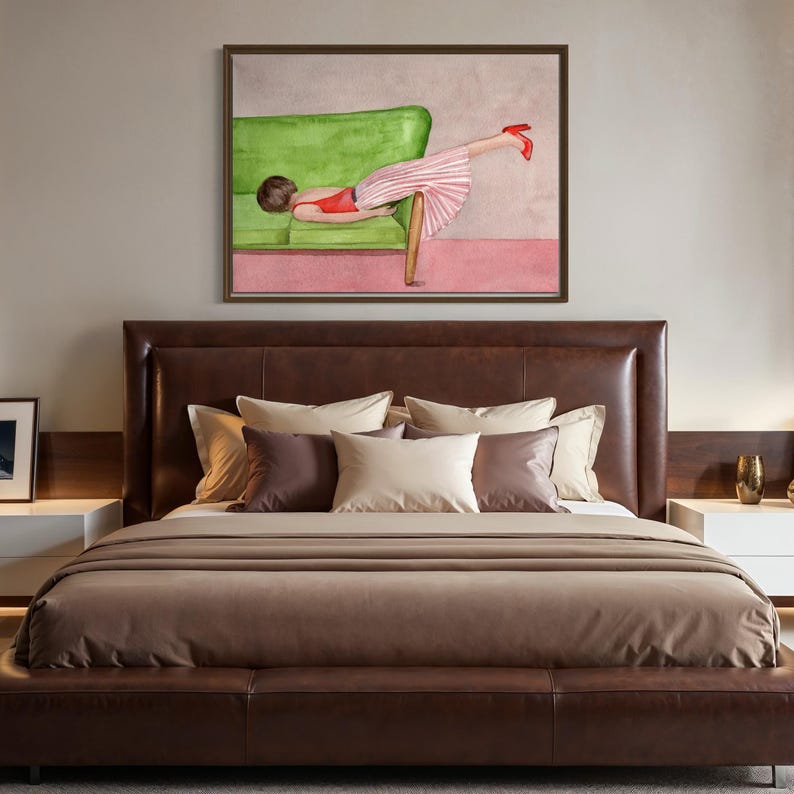 May include: Watercolor painting of a person reclining on a green sofa, wearing a red top and pink striped skirt, with red heels. The artwork is framed and hangs above a brown leather bed with pillows.
