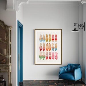 Op de afbeelding: Een ingelijst afdruk van een verzameling kleurrijke schoenen, waaronder rood, blauw, groen, geel en oranje. De schoenen zijn in rijen gerangschikt en zijn allemaal spitse ballerina's.