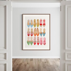 Op de afbeelding: Een ingelijst afdruk van een aquarel van 16 verschillende paar schoenen. De schoenen zijn allemaal in verschillende kleuren en stijlen, waaronder rood, groen, blauw, roze en geel. De schoenen zijn gerangschikt in een rasterpatroon.