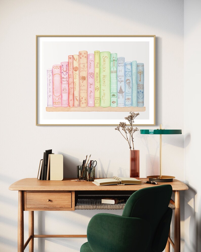 May include: A watercolour print featuring a collection of books in pastel shades. Titles visible include "Sherlock Holmes," "The Hobbit," and "Emma." The artwork is displayed in a gold-coloured frame, adding a touch of elegance to the scene.