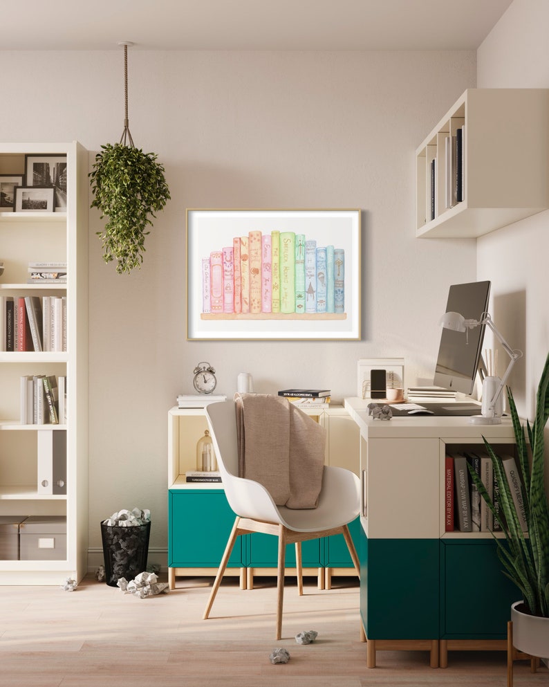 May include: A framed print featuring a collection of colourful books. The books are arranged on a wooden shelf, with a gold frame. The spines of the books are in shades of pink, yellow, green, and blue. The print is displayed in a modern office setting.
