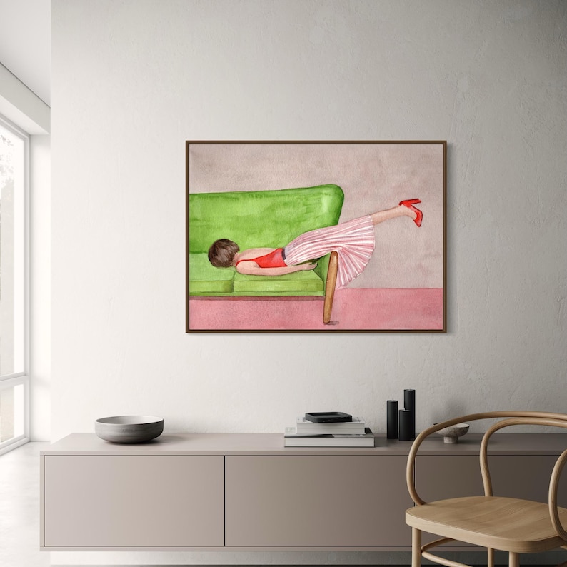 May include: Watercolor painting of a person reclining on a green sofa, wearing a red top, a pink and white striped skirt, and red heels. The artwork is framed in a brown wooden frame, with a pink and gray background.