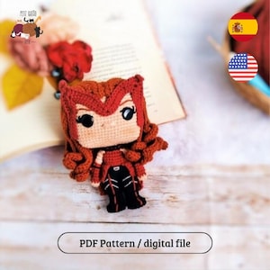 Pode incluir: Boneca de crochê feita à mão, com cabelo ruivo e roupa vermelha. A boneca tem olhos grandes e pretos e está colocada em um livro. O texto "PDF Pattern / digital file" está na parte inferior da imagem.