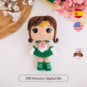 Puede incluir: Muñeca de ganchillo con cabello castaño, ojos negros grandes y un atuendo verde y blanco. La muñeca tiene una flor en el pecho y lleva botas verdes. El texto "PDF Pattern / digital file" está en la parte inferior de la imagen.