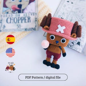Puede incluir: Muñeco de Chopper tejido a crochet de la serie de anime One Piece. El muñeco tiene un sombrero rosa con una cruz blanca, pelaje marrón y pantalones cortos granate. Sostiene una bola rosa. La imagen incluye un póster "Dead or Alive" y el texto "PDF Pattern / digital file."