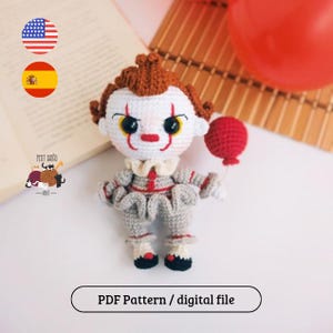 Pode incluir: Uma boneca de crochê com rosto branco, maquiagem vermelha, cabelo laranja e uma roupa cinza com babados. A boneca segura um pequeno balão vermelho em uma das mãos. O texto "PDF Pattern / digital file" está na parte inferior.