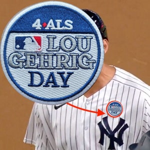May include: A white and blue baseball patch with the text "4 ALS LOU GEHRIG DAY" and a baseball logo. The patch is worn on a baseball uniform.