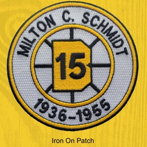 May include: White and yellow round iron-on patch with black text. The text reads "Milton C. Schmidt" and "1936-1955". A yellow square with the number "15" is in the center.