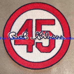 May include: Red and white embroidered baseball patch with the number 45 in a white circle with a red outline. The number 45 is outlined in navy blue. The text "Bob " is embroidered in navy blue above the number 4.