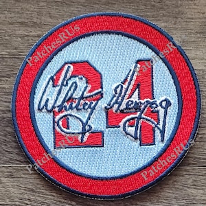 May include: A red, white, and blue embroidered patch with the number "24" and the name "Whitley" and "Mercer" in cursive.