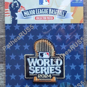 May include: A blue and white World Series patch with a baseball bat and the text "World Series 2024". The patch is on a white background with a blue border.