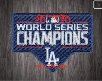 May include: A blue and red embroidered patch with the text "2020 World Series Champions LA" in white lettering. The patch is shaped like a triangle with a rounded top.
