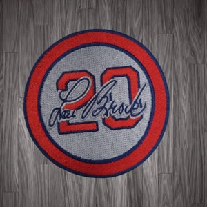May include: A red, white, and blue embroidered patch with the number "20" and the signature "Joe  Brooks".