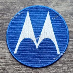 May include: A blue and white embroidered patch with the Motorola logo. The logo is a stylized "M" shape.