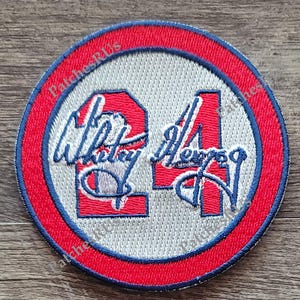 May include: A red, white, and blue embroidered patch with the number "21" and the name "Whitty" and "Alvero" written in cursive.