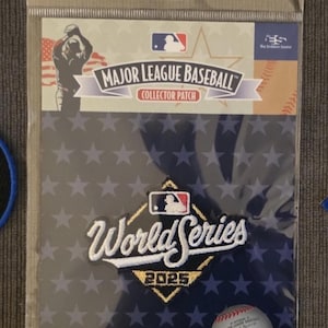 May include: A Major League Baseball collector patch in a clear plastic package. The patch features the MLB logo, the words "World Series 2025", and a baseball graphic. The background is navy blue with white stars.