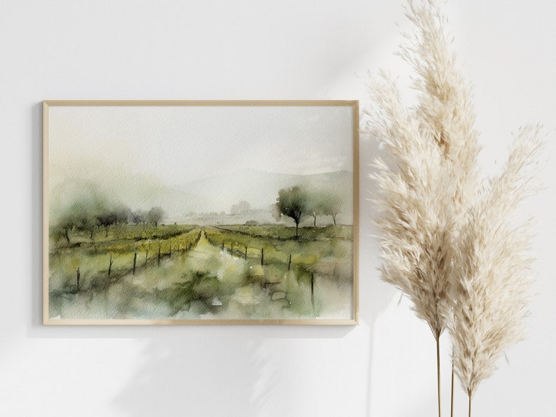 Op de afbeelding: Een aquarel van een mistig landschap met een zandweg die door een veld met bomen en een hek loopt. Het schilderij is ingelijst in een licht houten lijst.