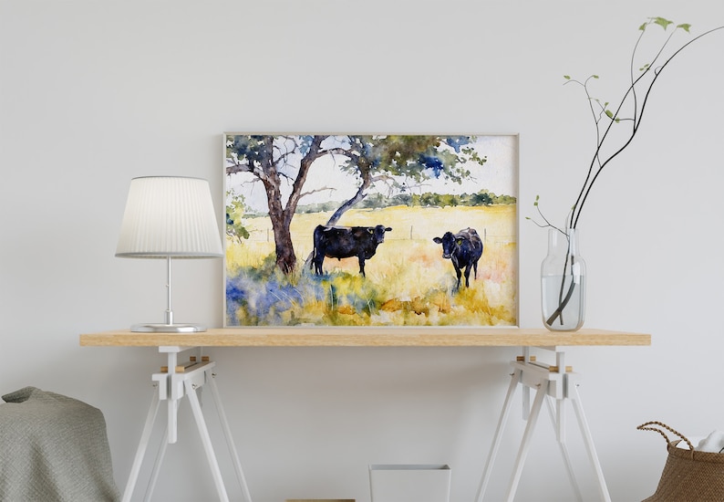 May include: Watercolour painting of two black cows standing in a field with a tree in the background.