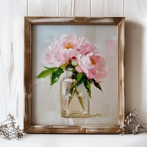 May include: A framed painting of pink peonies in a clear glass vase. The flowers have yellow centers and green leaves. The painting is in a distressed gold-colored wooden frame, set against a light gray background.